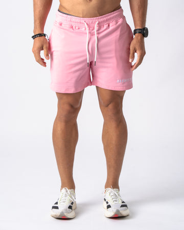 Person wearing pink shorts on a white background